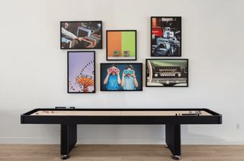 A pool table in a room with pictures on the wall